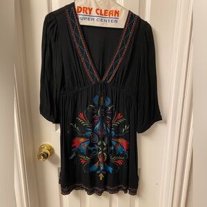 Black mini dress. Low v-neck. Pretty design on front and bottom.